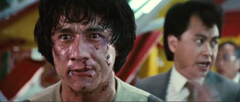 Movie still from “Police Story” (1985), directed by Jackie Chan – A person with blood on his face; Close Up shot, Low angle
