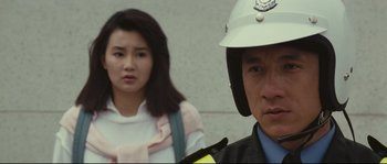 Movie still from “Police Story 2” (1988), directed by Jackie Chan – A man and a woman in a police uniform stand side by side; Close Up shot, Over the shoulder angle