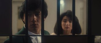 Movie still from “Police Story 2” (1988), directed by Jackie Chan – A man and a woman looking at each other through a window; Close Up shot, Low angle