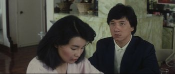 Movie still from “Police Story 2” (1988), directed by Jackie Chan – A man and a woman sitting next to each other in a room; Close Up shot, Over the shoulder angle
