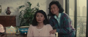 Movie still from “Police Story 2” (1988), directed by Jackie Chan – A woman standing next to another woman in a room; Medium shot, High angle
