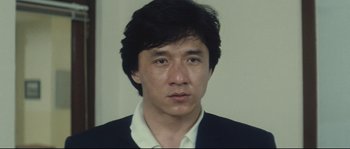 Movie still from “Police Story 2” (1988), directed by Jackie Chan – A person wearing a suit and tie; Close Up shot, Low angle