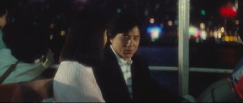 Movie still from “Police Story 2” (1988), directed by Jackie Chan – A man and a woman are standing in a dark room; Medium shot, Over the shoulder angle