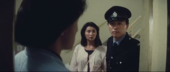 Movie still from “Police Story 2” (1988), directed by Jackie Chan – A woman and a man in uniform looking in a mirror; Medium shot, Over the shoulder angle