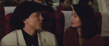 Movie still from “Police Story 2” (1988), directed by Jackie Chan – A man and a woman sitting next to each other on a train; Close Up shot, Over the shoulder angle