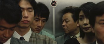Movie still from “Police Story 2” (1988), directed by Jackie Chan – A group of men standing next to each other in an elevator; Close Up shot, Over the shoulder angle