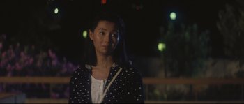 Movie still from “Police Story 2” (1988), directed by Jackie Chan – A woman standing in the dark at night; Close Up shot, Over the shoulder angle