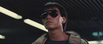 Movie still from “Police Story 2” (1988), directed by Jackie Chan – A person wearing sunglasses; Close Up shot, Low angle