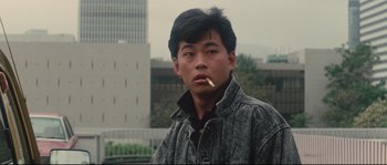 Movie still from “Police Story 2” (1988), directed by Jackie Chan – A man with a cigarette in his mouth; Close Up shot, Low angle