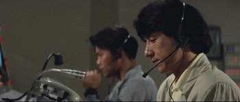 Movie still from “Police Story 2” (1988), directed by Jackie Chan – Two men wearing headsets and talking on a microphone; Close Up shot, Low angle