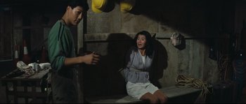 Movie still from “Police Story 2” (1988), directed by Jackie Chan – A man and a woman sitting on a bench; Medium shot, High angle