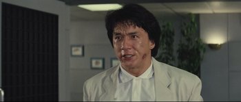 Movie still from “Police Story 2” (1988), directed by Jackie Chan – A man in a white shirt and a white jacket; Close Up shot, Low angle