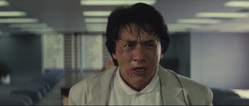 Movie still from “Police Story 2” (1988), directed by Jackie Chan – A person wearing a white shirt; Close Up shot, Low angle