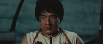 Movie still from “Police Story 2” (1988), directed by Jackie Chan – A person wearing a white shirt; Close Up shot, Low angle