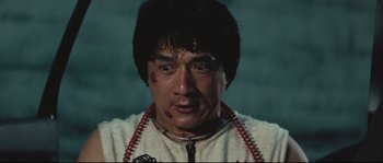 Movie still from “Police Story 2” (1988), directed by Jackie Chan – A person wearing a white shirt; Close Up shot, Low angle