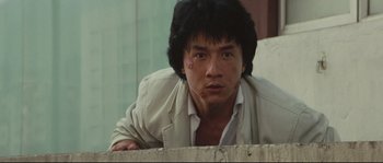 Movie still from “Police Story 2” (1988), directed by Jackie Chan – A person leaning on a wall; Close Up shot, Low angle