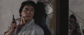Movie still from “Police Story 2” (1988), directed by Jackie Chan – A man standing in front of a wall with a shadow of himself; Close Up shot, Low angle