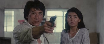 Movie still from “Police Story 2” (1988), directed by Jackie Chan – A man and a woman holding a gun in a room; Close Up shot, Low angle