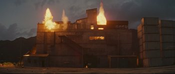 Movie still from “Police Story 2” (1988), directed by Jackie Chan – A building that has a lot of fire coming out of it; Extreme Wide shot, Low angle