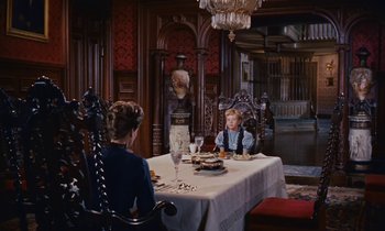 Movie still from “Pollyanna” (1960), directed by David Swift – Two people sitting at a table in a dining room; Wide shot, High angle