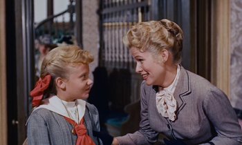Movie still from “Pollyanna” (1960), directed by David Swift – A woman and a young girl talking to each other; Medium shot, Over the shoulder angle