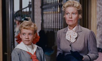 Movie still from “Pollyanna” (1960), directed by David Swift – A woman and a young boy are standing next to each other; Close Up shot, Low angle