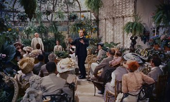 Movie still from “Pollyanna” (1960), directed by David Swift – A group of people sitting in a room with plants; Wide shot, High angle