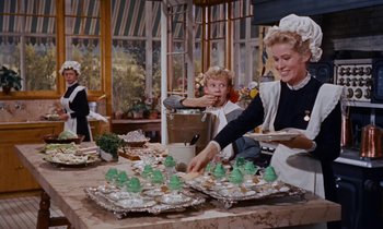 Movie still from “Pollyanna” (1960), directed by David Swift – A woman and a little girl are serving food; Medium shot, High angle
