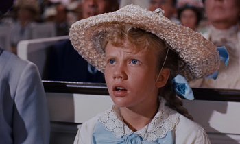 Movie still from “Pollyanna” (1960), directed by David Swift – A little girl wearing a straw hat and a blue dress; Close Up shot, Low angle