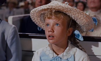 Movie still from “Pollyanna” (1960), directed by David Swift – A little girl wearing a straw hat and a blue dress; Close Up shot, Low angle