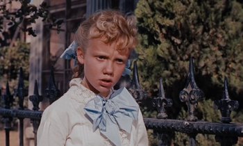 Movie still from “Pollyanna” (1960), directed by David Swift – A young girl in a white shirt and a blue bow tie; Close Up shot, Low angle