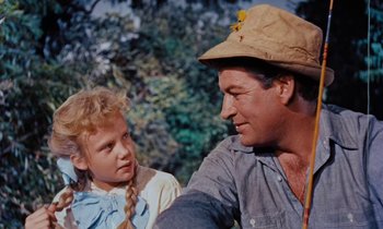 Movie still from “Pollyanna” (1960), directed by David Swift – A man and a little girl sitting next to each other; Close Up shot, Low angle