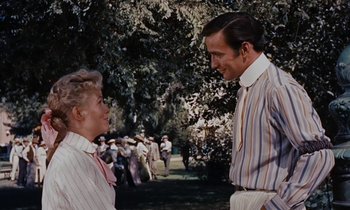 Movie still from “Pollyanna” (1960), directed by David Swift – A man and a woman talking in front of a group of people; Medium shot, Over the shoulder angle