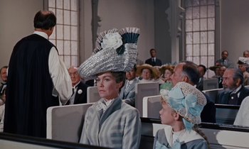 Movie still from “Pollyanna” (1960), directed by David Swift – A group of people sitting in a room with hats on; Medium shot, Low angle