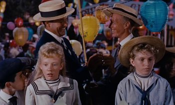 Movie still from “Pollyanna” (1960), directed by David Swift – Two men and two children in a crowd of people wearing hats; Medium shot, High angle