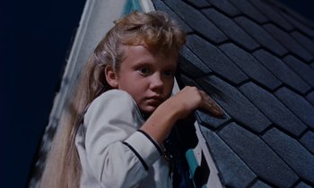 Movie still from “Pollyanna” (1960), directed by David Swift – A young girl leaning against a roof with a hand on the roof; Close Up shot, Low angle