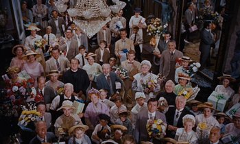 Movie still from “Pollyanna” (1960), directed by David Swift – A large group of people gathered together in a room; Wide shot, High angle