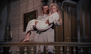 Movie still from “Pollyanna” (1960), directed by David Swift – A man and a little girl standing next to a railing; Medium shot, Low angle