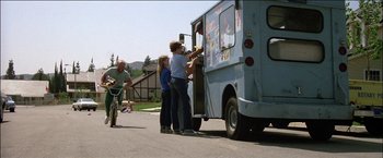 Movie still from “Poltergeist” (1982), directed by Tobe Hooper – Two children are loading up a blue ice cream truck; Wide shot, Low angle