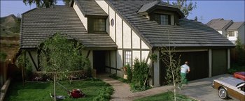 Movie still from “Poltergeist” (1982), directed by Tobe Hooper – A house that has a lawn mower in front of it; Extreme Wide shot, High angle