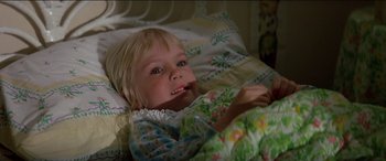 Movie still from “Poltergeist” (1982), directed by Tobe Hooper – A little girl laying in a bed with a blanket; Close Up shot, High angle