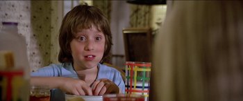 Movie still from “Poltergeist” (1982), directed by Tobe Hooper – A young boy sitting at a table with a plate of food; Close Up shot, Low angle