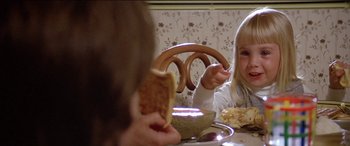 Movie still from “Poltergeist” (1982), directed by Tobe Hooper – Two little girls sitting at a table eating a sandwich; Close Up shot, Over the shoulder angle