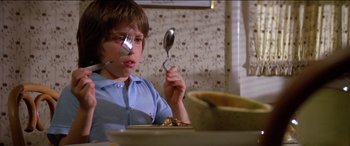 Movie still from “Poltergeist” (1982), directed by Tobe Hooper – A young boy holding a spoon in front of his face; Close Up shot, High angle