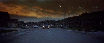 Movie still from “Poltergeist” (1982), directed by Tobe Hooper – A car is driving down the street at night; Extreme Wide shot, Low angle