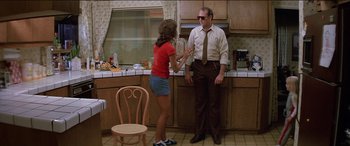 Movie still from “Poltergeist” (1982), directed by Tobe Hooper – A man and a woman standing in a kitchen talking; Medium shot, Low angle