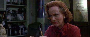 Movie still from “Poltergeist” (1982), directed by Tobe Hooper – An older woman is sitting at a table with a pencil; Close Up shot, Over the shoulder angle