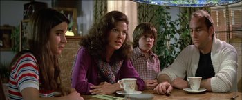 Movie still from “Poltergeist” (1982), directed by Tobe Hooper – A woman sitting at a table with a cup of coffee; Medium shot, Over the shoulder angle