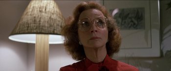 Movie still from “Poltergeist” (1982), directed by Tobe Hooper – An older woman wearing glasses and a red shirt; Close Up shot, Low angle