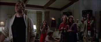 Movie still from “Poltergeist” (1982), directed by Tobe Hooper – A group of people standing in a living room holding microphones; Medium shot, Low angle